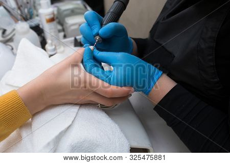 Close-up Of Professional Finger Nail Treatment, Grinding And Polishing With Electric Nail File Drill
