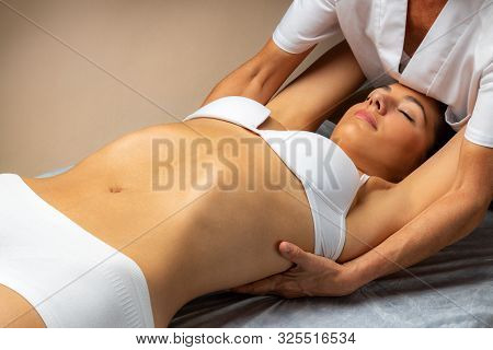 Close Up Of Physiotherapist Doing Shoulder Blade Therapy On Young Female Patient.woman Laying On Spa