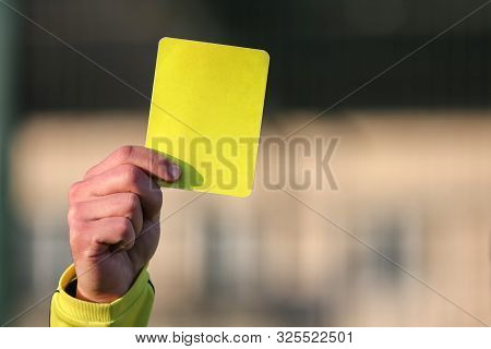 Football Referee Shows A Yellow Card. The Punishment For A Foul.