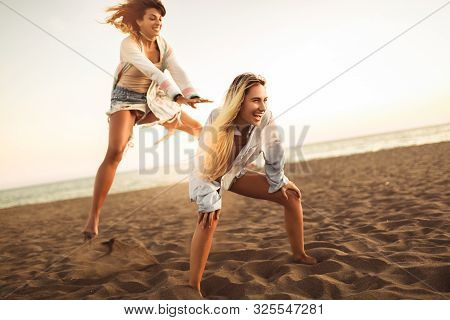 Happy Women On The Beach Playing Leap Frog, Having Fun, Selective Focus.