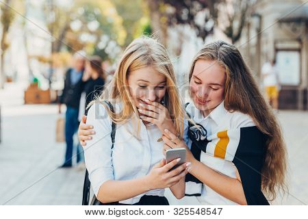 Happy Brightful Positive Moments Of Two Stylish Girls Hugging On Street In City. Closeup Portrait Fu