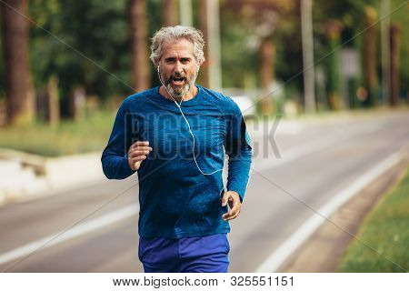 Active Senior Man Jogging On A Sunny Day