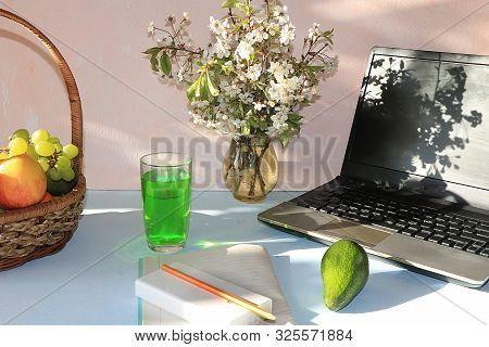 Workplace, Computer, Flowers, Empty Notebook With Pen And Basket With Grapes And Apples, Lime On A D