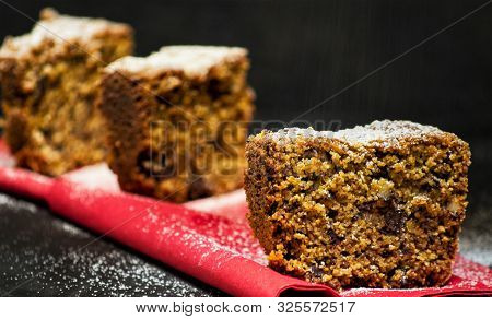 Homemade Tart Slices On A Black Background With Chocolate, Italian Amaretti Cookies, Nuts And Yogurt