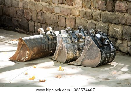 Spare Excavator Buckets That Are Stored Next To A Construction Site