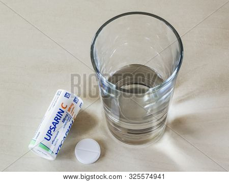 Varna, Bulgaria, October 02, 2019. Top View Of Upsarin C Antipyretic Tablets And Glass Of Water On A