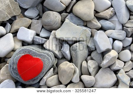 Red Heart On A Figured Stone. Many Gray Stones