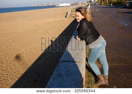 Happy Young Curvy Woman Looking Up Outdoors In Fall. Girl Enjoying Warm Sunny Weather. She Wearing I
