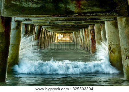 Waves Crashing Into The Posts Under The Historic Wharf At Tolaga Bay  Gisborne Region Of New Zealand