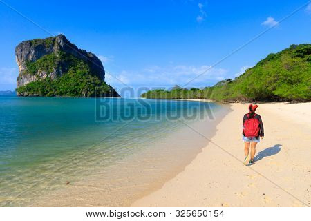 Woman walking on a pure and clean deserted tropical beach, Thailand