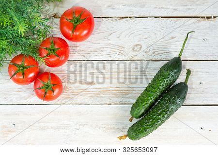 Harvest. Red Tomatoes With A Green Stem. Fresh Pimply Cucumbers. Space For Your Text.