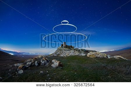 beautiful sky at night with light circles and silhouette of old Enisala fortress, Dobrogea, Romania