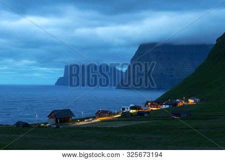Small village of Trollanes near Kallur lighthouse on Kalsoy island in evening time, Faroe Islands, Denmark. Landscape photography