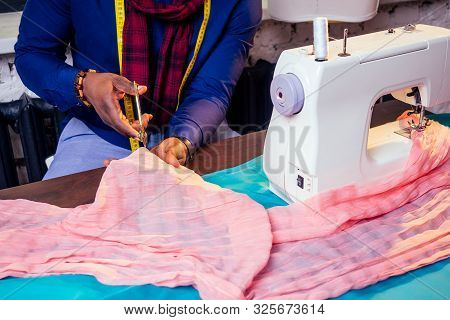 Portrait Of A Handsome African Man Smiling Seamstress With Sewing Machine.afrio American Man Stylish