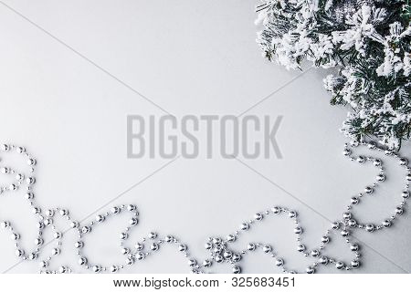 Christmas Beads Near A Snowy Fir Branch On A Shogo Background With Sparkles. Retro Style. Merry Chri