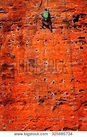 Rock climbing on red sandstone for sport recreation challenge and fun