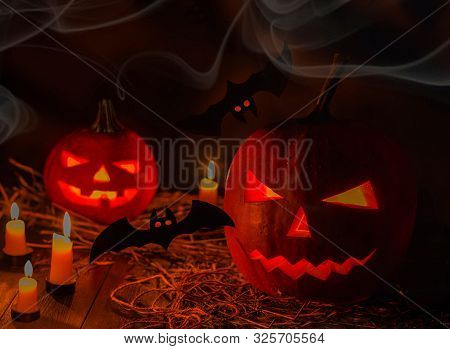 Helloween Pumpkin With Candles, Smoke And Bats On Black Background. Big Spooky Helloween Symbol