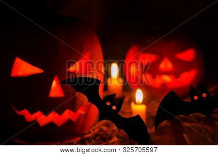 Helloween Pumpkin With Candles And Bats On Black Background. Big Spooky Helloween Symbol. Selective 