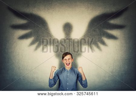 Furious Teenage Boy Holding Fists Up And Screaming Showing His Powers. Confident Adolescent Guy Cast