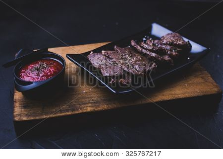 Beef Steak Sliced. Beef Steak Cut Into Strips On A Cutting Board With Tomato Sauce On The Side.