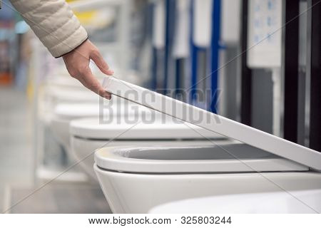 Buyer Choosing A New Toilet Sanitary Ware On Construction Store.