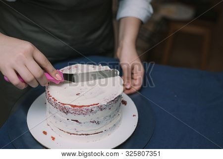 The Confectioner Levels The Cream On The Cake. The Cook Creates A Cake, Collects It And Covers It Wi