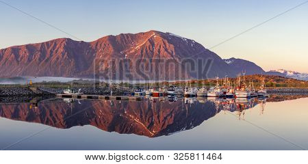 Laukvik, Lofoten Islands, Norway, Fishing boats in harbor at midnight sun, Mountain With Snow In Background