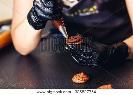 Pastry Chef Squeezes Chocolate Cream From A Pastry Bag Onto Cookies. Making Chocolate Cookie Sandwic