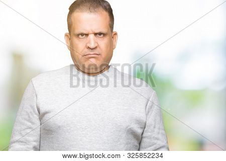 Middle age arab man wearing sport sweatshirt over isolated background skeptic and nervous, frowning upset because of problem. Negative person.
