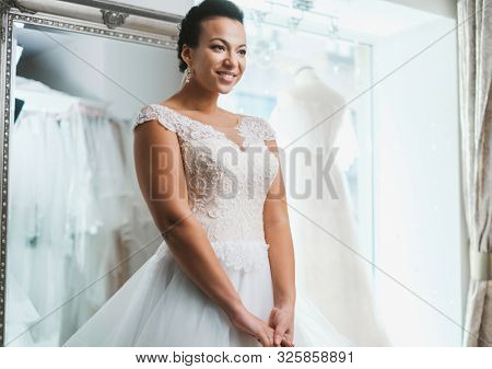 Beautifu bride choosing wedding dress in a wedding salon