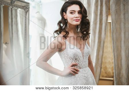 Beautifu bride choosing wedding dress in a wedding salon