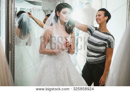 Beautifu bride choosing wedding dress in a wedding salon