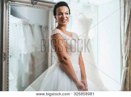 Beautifu bride choosing wedding dress in a wedding salon