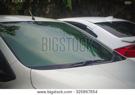 Section Of The Front Of A White Vehicle And Its Front Windscreen Bonnet And Wipers.