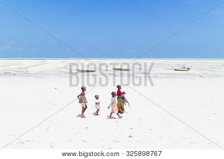 Paje, Zanzibar - Feb 9, 2015: Local Kids Walking At Paje Village Picture Perfect White Beach At Low 