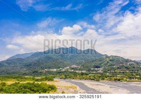 landscape of golden miscanthus with mountain and river under sky