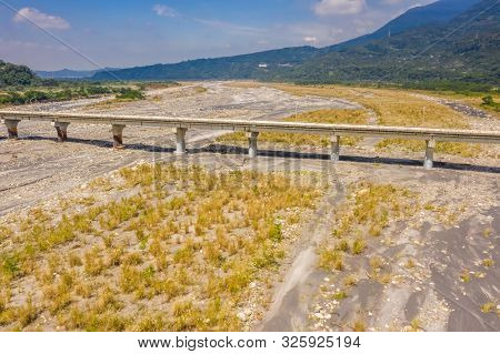 bridge over river with golden miscanthus under sky