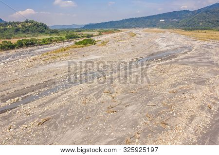 landscape of golden miscanthus with mountain and river under sky