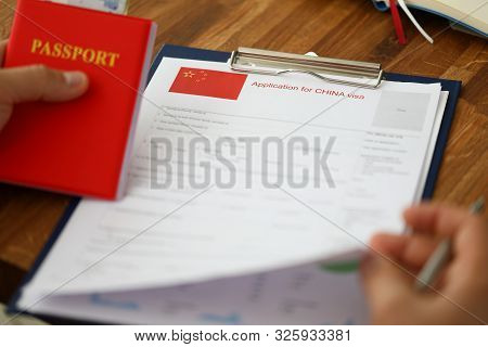 Male Hand Hold Silver Pen With Passport. Filling China Apllication Form Concept