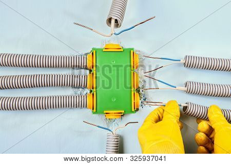 Electric Services, Electrician Connects The Electrical Conduit To A Rectangular Plastic Distribution