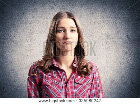 Unhappy Young Woman Looking At Camera. Emotional Brown Haired Woman Has Displeased Facial Expression