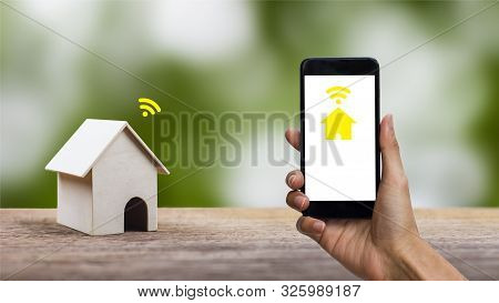 Smart Home Future Technology Concept. A Man Hand Using Smartphone Control Everything At Home By Inte