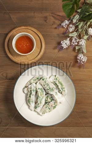 Top View Vietnamese Steamed Rice Dumplings Served With Spicy Chili Sauce Over Wooden Table