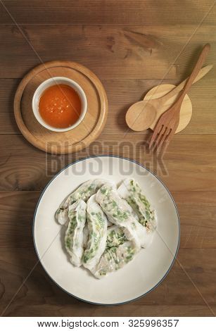 Top View Vietnamese Steamed Rice Dumplings Served With Spicy Chili Sauce Over Wooden Table