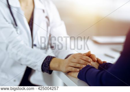 Unknown Woman-doctor Is Holding Her Patients Hands, Discussing Current Health Examination, While The