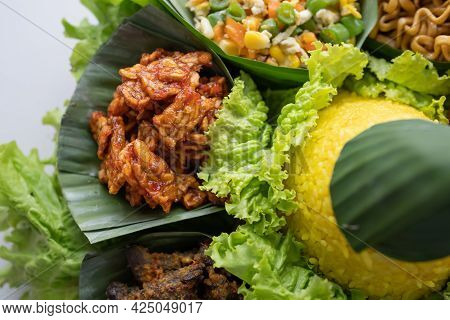 Nasi Tumpeng. Indonesian Cuisine Yellow Rice On Banana Leaf