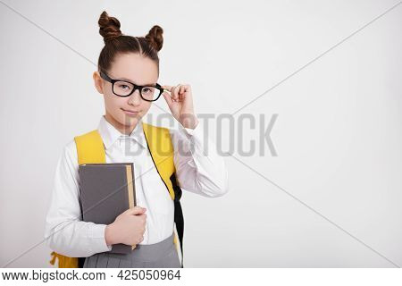 Education And Eyevision Concept - Portrait Of Cute Girl In School Uniform And Eyeglasses With Backpa