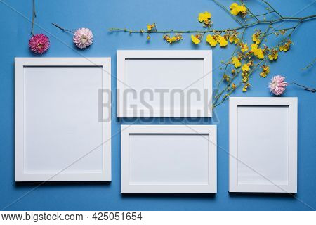 Blank Empty Picture Frames With Copy Space And Oncidium Orchid Flowers Branch On The Blue Flat Lay B