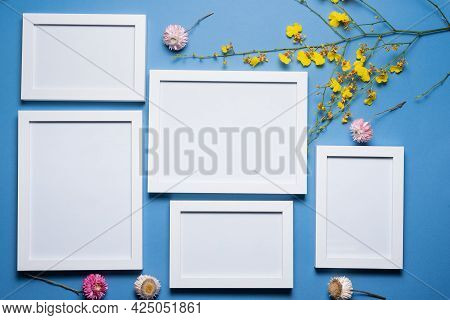 Blank Empty Picture Frames With Copy Space And Oncidium Orchid Flowers Branch On The Blue Flat Lay B