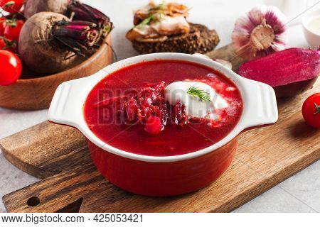 Delicious Fresh Red Borscht, Garlic, Tomatoes And Beets On The Kitchen Table.